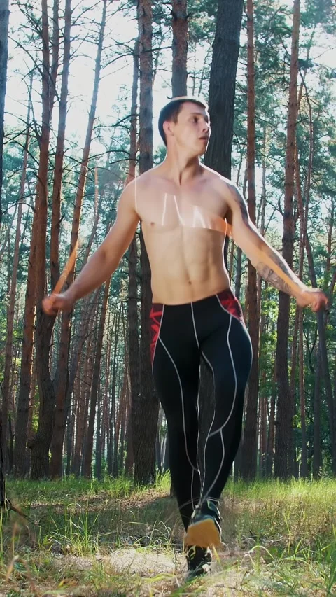 Athletic man with a bare, naked torso, jumping rope, performs strength exercises Stock Footage 312383024