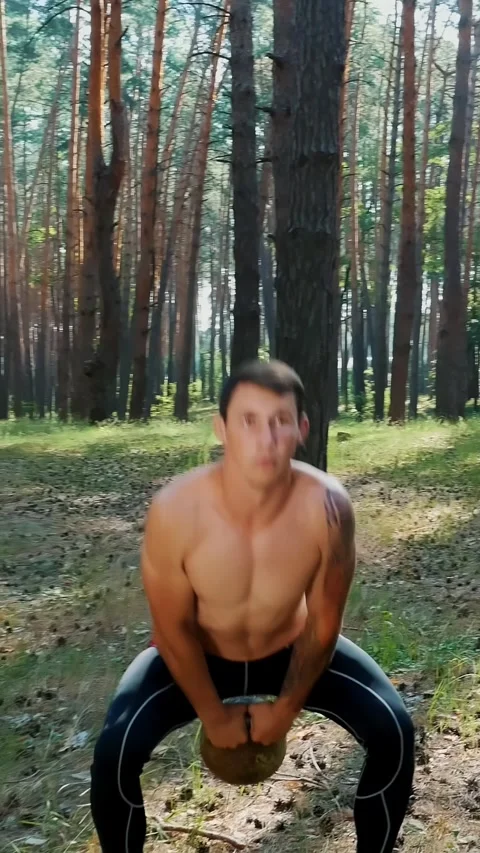Athletic man, with a bare, naked torso, performs strength exercises with weights Stock Footage 313483933