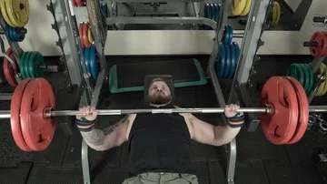 Athletic man with a beard doing a bench press in the gym close-up 4k. Stock Footage 85588362