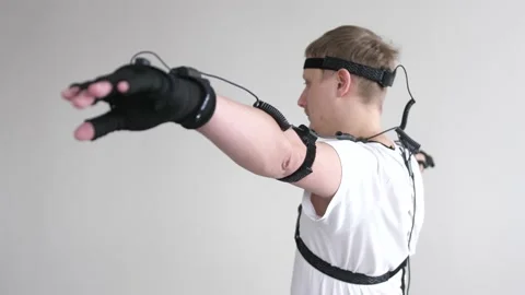 Athletic man with beard wears motion capture suit with sensors headset moving in Stock Footage 153426258