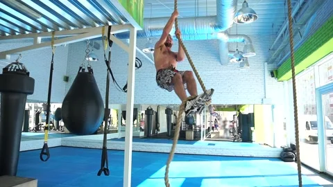 An athletic man climbs the rope up Stock Footage 140124671