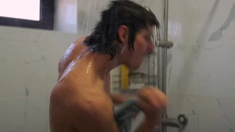 Athletic man dances with loofah, singing and grooving freely. Video stock 307887672