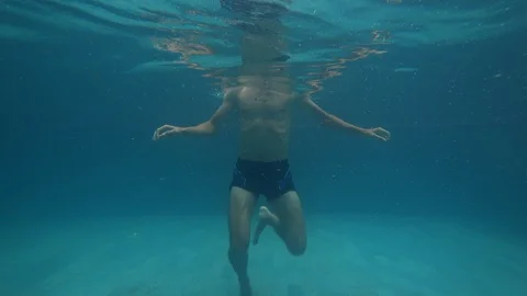 Athletic man is dancing having fun fooling around underwater  in pool Stock Footage 122977722