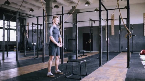 Athletic man does box jumps in factory gym Video stock 115159445