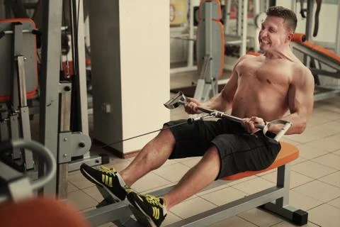 Athletic man does lat exercises Stock Photos