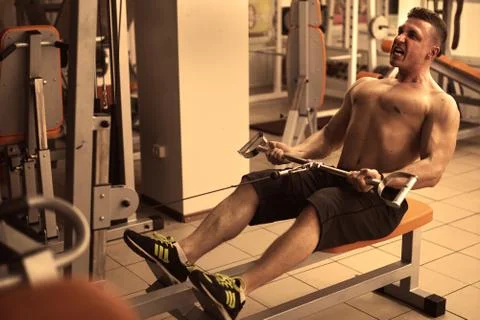 Athletic man does lat exercises Stock Photos