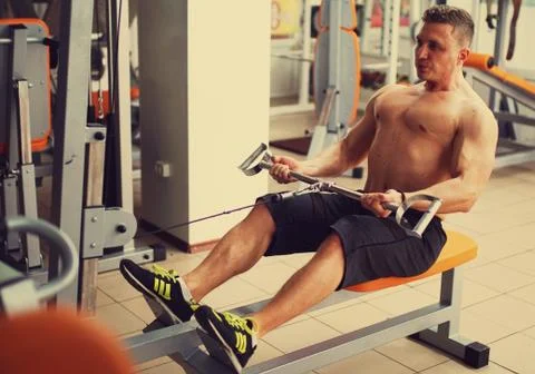 Athletic man does lat exercises Stockfoto's