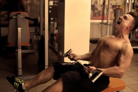 Athletic man does lat exercises Stockfoto's