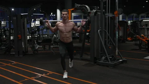 Athletic man doing barbell reverse lunge in gym. Athlete exercising with barbell Stock Footage 220333375