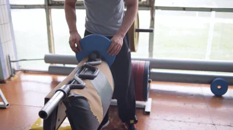 Athletic man doing biceps curls with EZ barbell Video stock 64319837