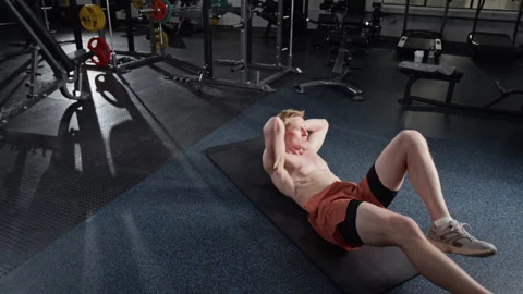 Athletic Man Doing Bicycle Crunches on Mat in Fitness Center Stock Footage 339909922
