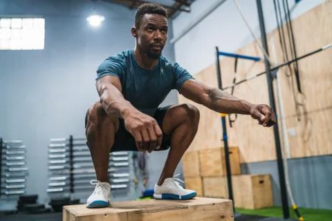 Athletic man doing box jump exercise. Stock Photos