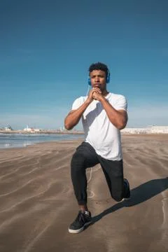 Athletic man doing exercise at the beach. Stock Photos