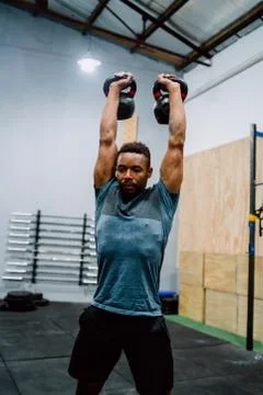 Athletic man doing exercise with crossfit kettlebel. Stock Photos