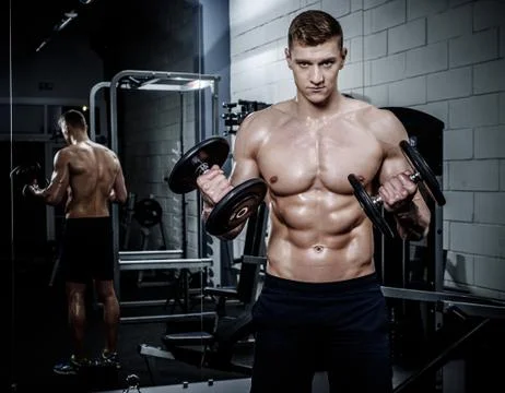 Athletic man doing exercises with dumbbells in The Gym's Studio Stock-Fotos