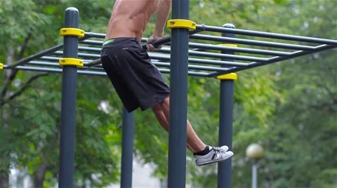 Athletic man doing gymnastics elements in City Park Stock Footage 66420653