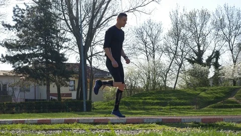 Athletic man doing legs exercises in park and warming up before running race  Stock Footage 77737355