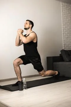 Athletic man doing lunge forward. Sport at home concept. Strong man stretching Stock Photos