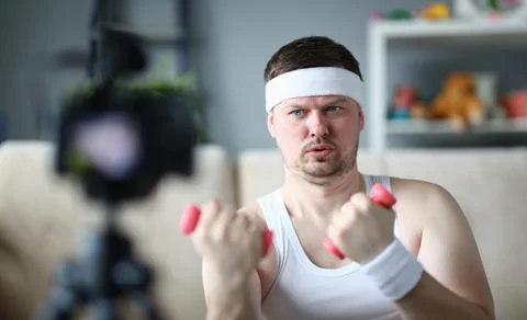 Athletic man doing physical exercises with dumbbells on camera Stock Photos