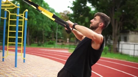 An athletic man doing push ups exercise using rubber belt to force strenth of 스톡 동영상 139453110