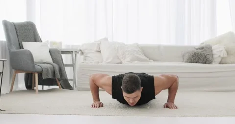 Athletic man is doing push-ups exercises on workout at home during lockdown. Stock Footage 143924208