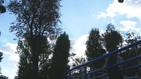 Athletic man doing push ups on parallel bars at sports ground in city park Stock Photos