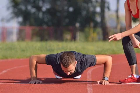 Athletic man doing push-ups during outdoor cross training workout Stock Photos