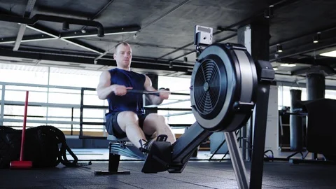 Athletic man doing set of exercise on rope pull machine Stock Footage 108970563