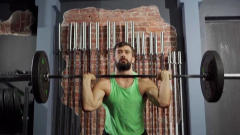 Athletic man doing squats with barbell Stock Footage 124833050