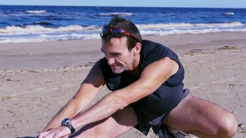 Athletic man doing squats on summer beach Stock Footage 82413710