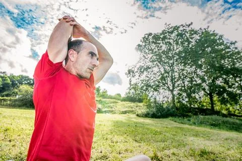 Athletic man doing stretching in nature Stock Photos