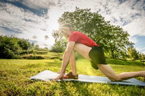 Athletic man doing stretching in nature Stock Photos