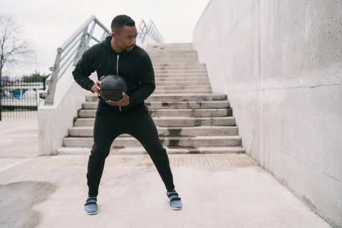 Athletic man doing wall ball exercise. Stock Photos