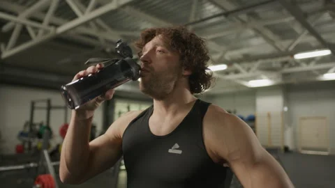 Athletic Man Drinking Water from Bottle in Gym Stock Footage 302503958