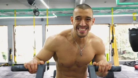 Athletic man engaged in intense workout on fitness machine, strength Stock Footage 319067097