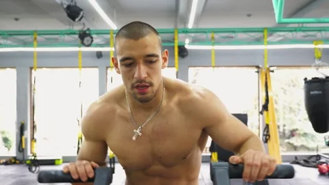 Athletic man engaged in intense workout on fitness machine, showcasing 库存影片 332849622