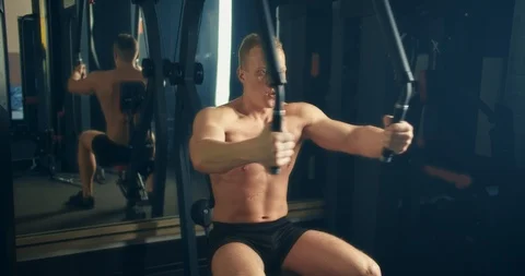 Athletic man engages with peck deck machine in the gym middle view Ukraine Lviv Stock Footage 127322009