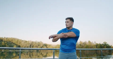 An Athletic Man Engaging in Stretching Exercises Before His Outdoor Workout Stock Footage 318072705