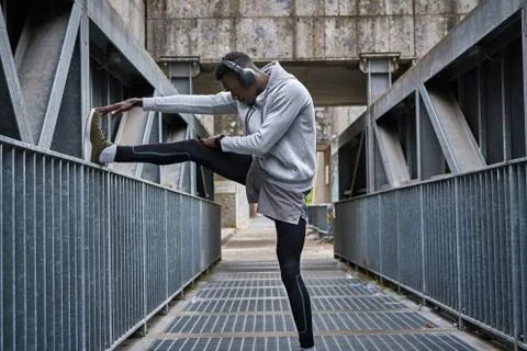 Athletic man is exercising on the bridge Stock Photos