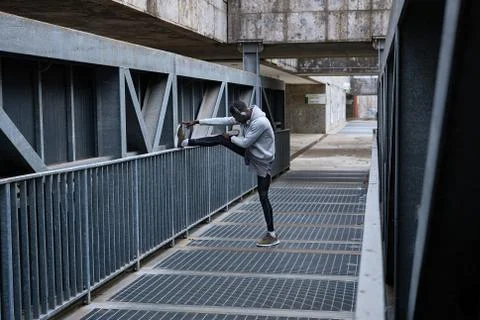 Athletic man is exercising on the bridge Stock Photos