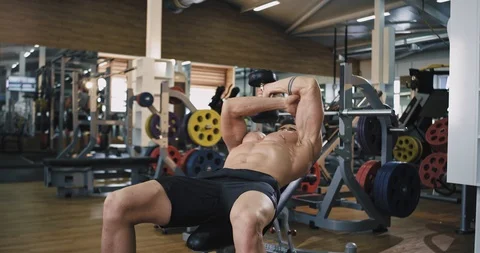 Athletic man in a gym class make a biceps exercise lifting up the dumbbell Video stock 114763781