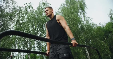 Athletic man has workout, hanging and pull up on parallel bars outdoors Stock Footage 249987181