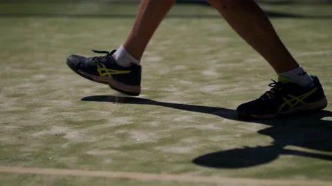 Athletic man hitting the ball during a padel match. Close up shot on legs Stock Footage 141883981