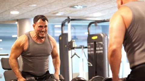 Athletic man with intense facial expression doing dumbbell lateral raises i.. Stock-Footage 344052797