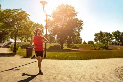 Athletic man jogging in the park. Stock Photos