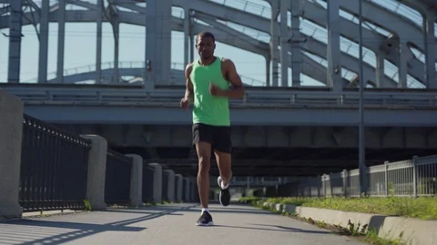 Athletic man jogging on urban bridge Video stock 117061542