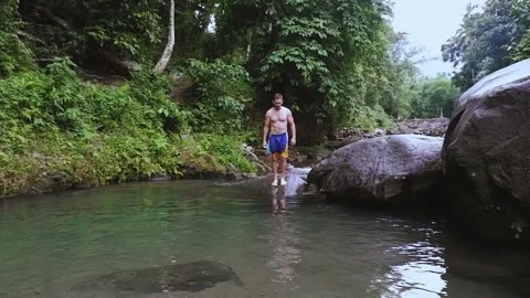An athletic man jumps into the river. Video stock 137687216