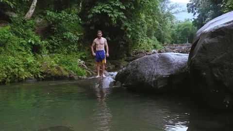An athletic man jumps into the river. Video stock 137687271