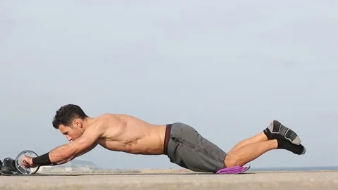 Athletic man makes exercise with wheel 動画素材 73950569