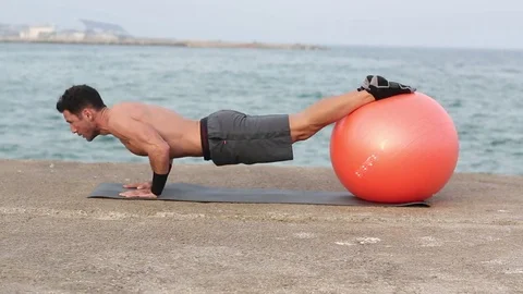 Athletic man making push-ups on abdominal ball 動画素材 73950610